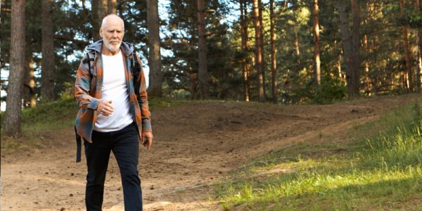 Man wandelt buiten in de natuur, om zo zijn artrose klachten te verminderen